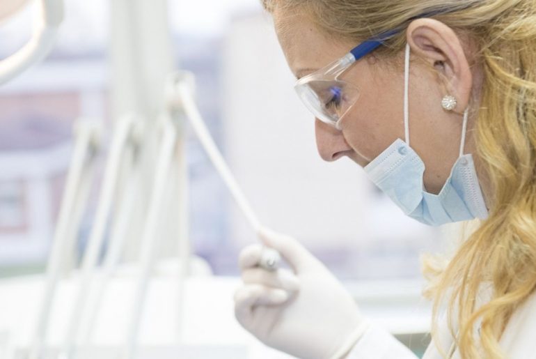 Asystentka stomatologiczna z urządzeniem dentystycznym w dłoni