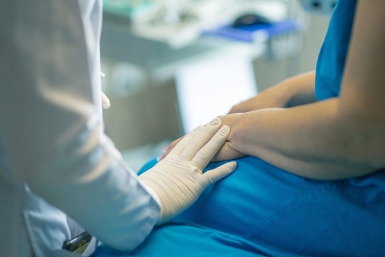 Pracownik medyczny trzymający pacjenta za dłoń