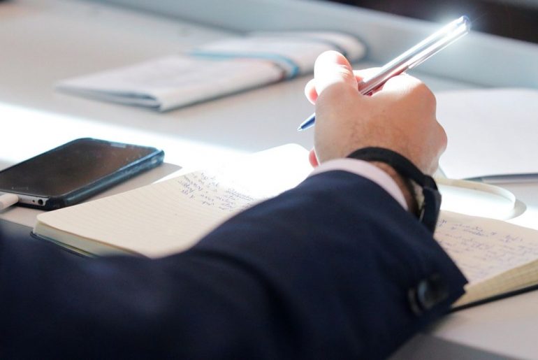 Osoba tworząca notatki na zajęciach