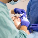 Dentysta i asystentka podczas zabiegu na pacjencie