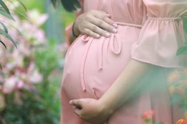 Kobieta trzymająca się za brzuch ciążowy